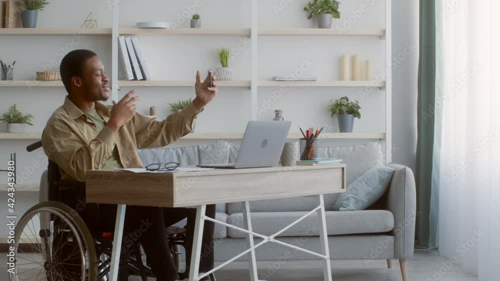 Handicapped Man Video Calling On Smartphone Sitting In Wheelchair Indoor Handicapped Man Video Calling On Smartphone Sitting In Wheelchair Indoor