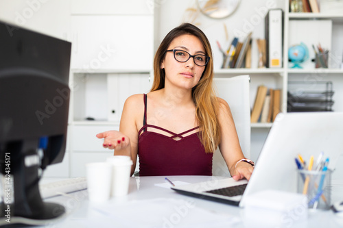 Portrait of smiling female worker engaged in business activities at workplace in office