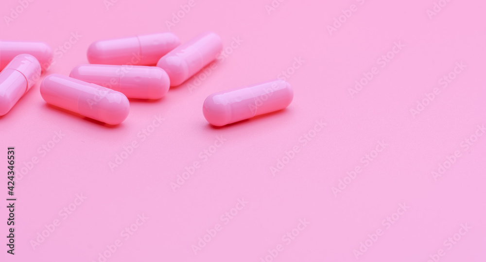 Pink capsule pills on pink background. Vitamin and supplement for healthy skin use in beauty clinic for treatment wrinkle and acne skin. Pharmacy store web banner. Pharmaceutical industry. Happy pill.