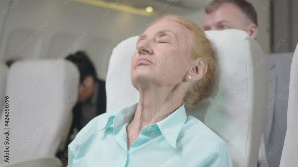 Passenger adult businesswoman tired sleepy, elderly with blanket during trip on the airplane, Traveling woman senior sleeping in a chair of the plane