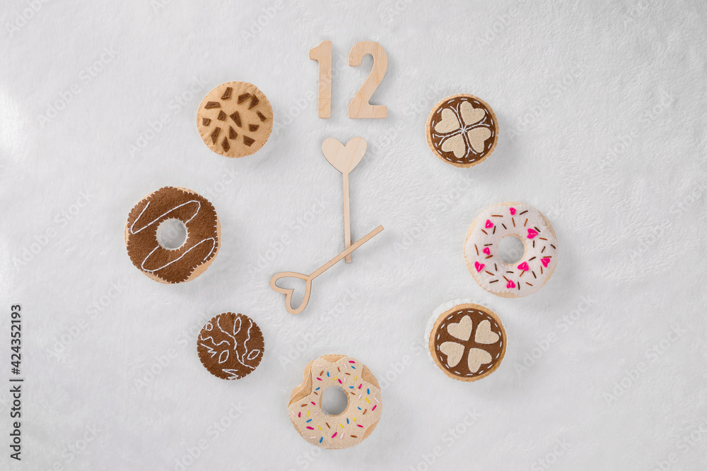 A clock made from a set of soft bagels and cookies are on a light soft textile. It is seven o'clock. The concept of time for wake up, new day. A clock made from a set of soft bagels and cookies are on a light soft textile. It is seven o'clock. The concept of time for wake up, new day.