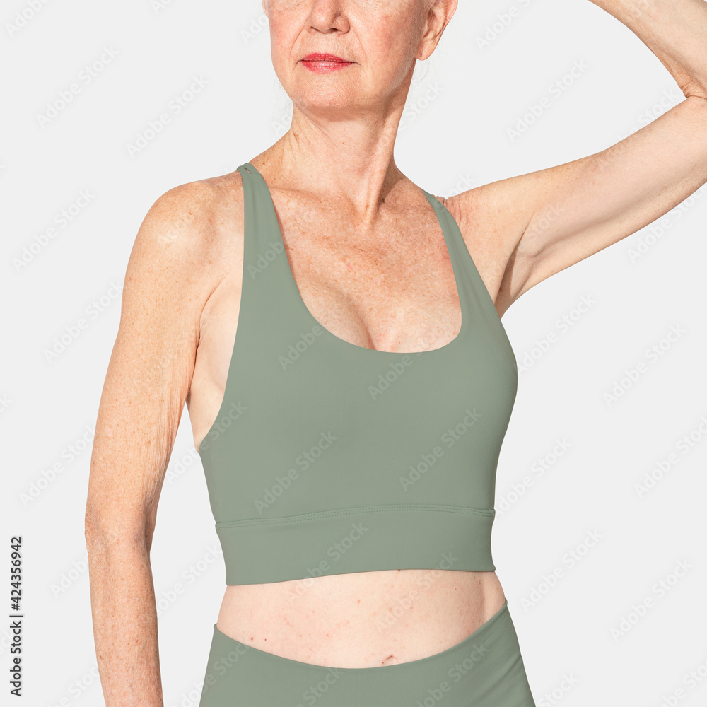 Healthy senior woman in green sports bra and leggings
