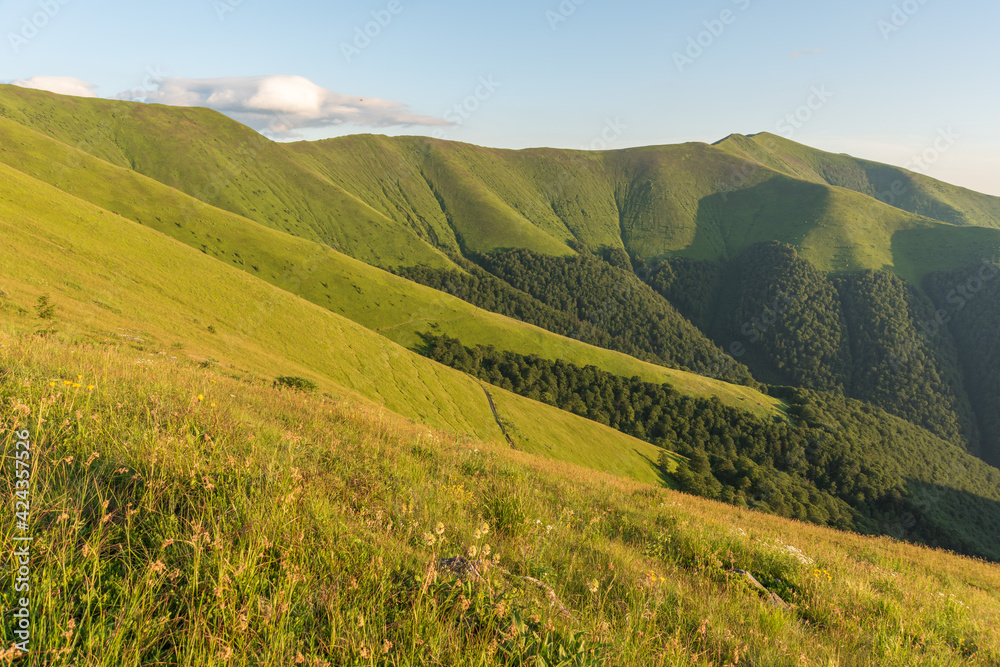 Naklejka premium Summer evening in the Ukrainian Carpathian mountains on Borzhava with a dramatic sunset and tourists watching it