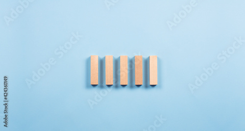 Wooden cubes bars. Stacked in a row. On a blue background. Construction and sequence concept