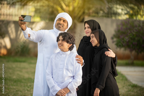 Arabian family taking selfie with phone  outdoors