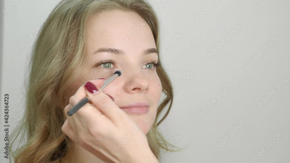 beautiful blonde in a beauty salon, does makeup beautiful blonde in a beauty salon, does makeup