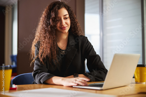 Beautiful young woman working on notebook in office