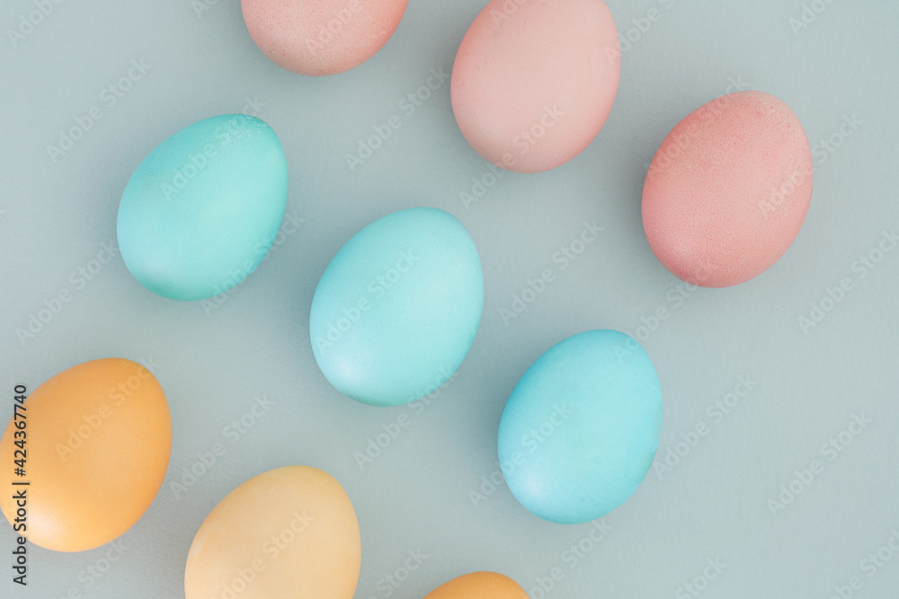 Blue, yellow and pink Easter eggs on a pastel blue background. Easter background, easter concept, top view, flat lay