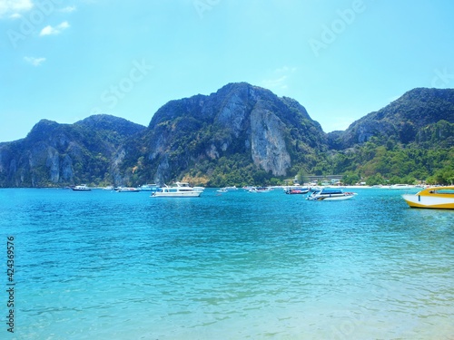 Tourist islands of Thailand. Cruise, traveling. Tropical resort. Boats and yachts anchored in the harbor. Sea bay. Rocks, sandy beach in the distance. Clear turquoise water. Seascape, panorama, beauty © Oxana