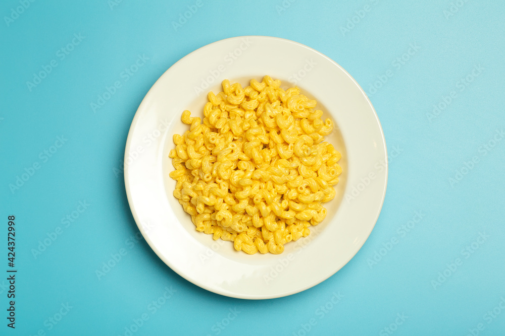 Pasta background. Mac and Cheese pasta on a blue background. American style Italian pasta with cheese. Pasta background. Mac and Cheese pasta on a blue background. American style Italian pasta with cheese.