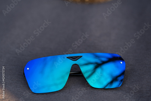 Futuristic sunglasses model rimless with blue lenses reflecting the sun in a summer day shoot outside closeup. Selective focus . High quality photo