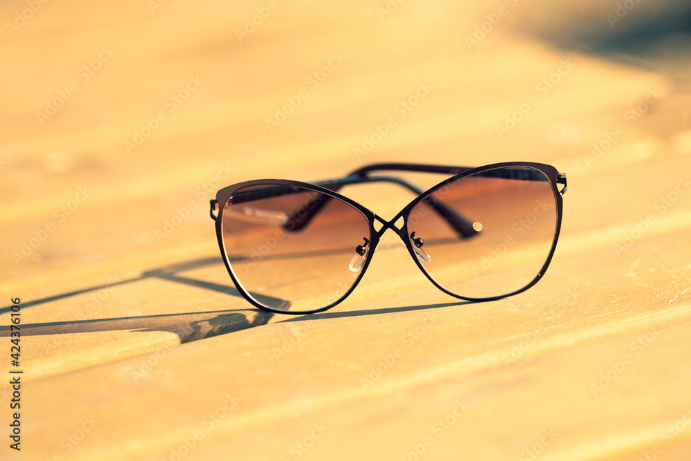 Fashion Sunglasses model for women with a special design shoot outside in nature in a summer day reflecting the sun. Selective focus. High quality photo Fashion Sunglasses model for women with a special design shoot outside in nature in a summer day reflecting the sun. Selective focus. High quality photo