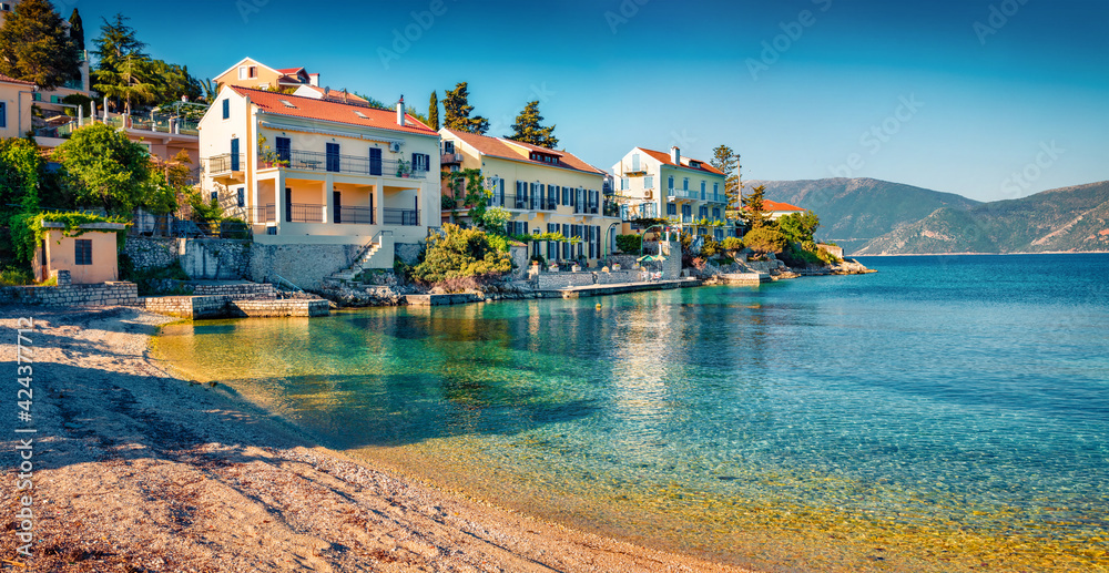 Fototapeta premium Beautiful marine scenery. Bright summer cityscape of Fiskardo town with Zavalata Beach. Stunning morning seascape of Ionian Sea. Wonderful outdoor scene of Kefalonia island, Greece, Europe.
