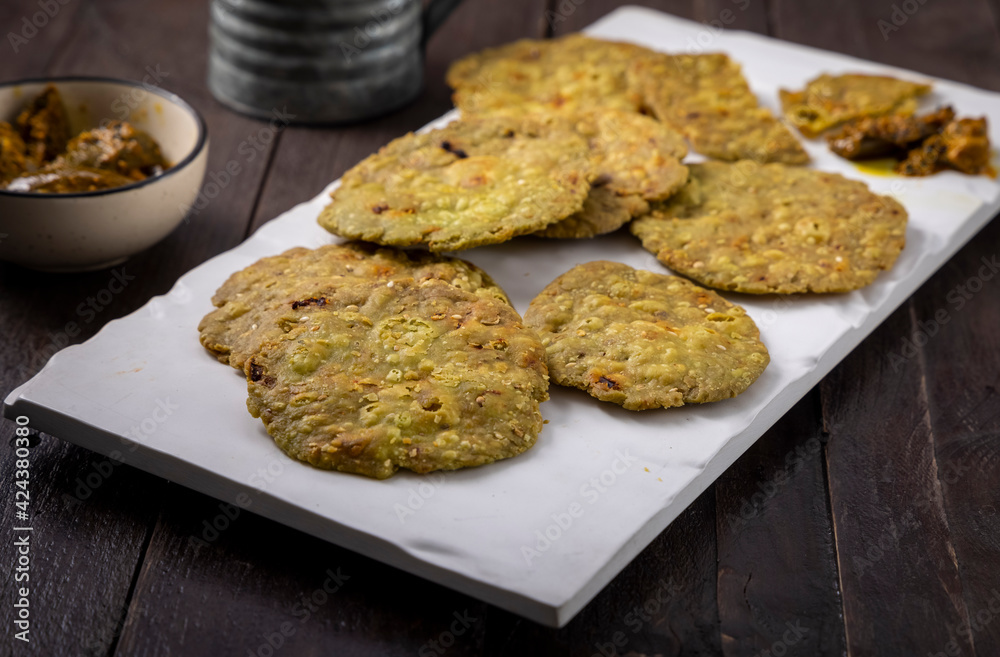 crispy and salty mathri with mango pickle on a white tray crispy and salty mathri with mango pickle on a white tray