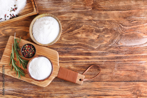 Bowls of salt on wooden background
