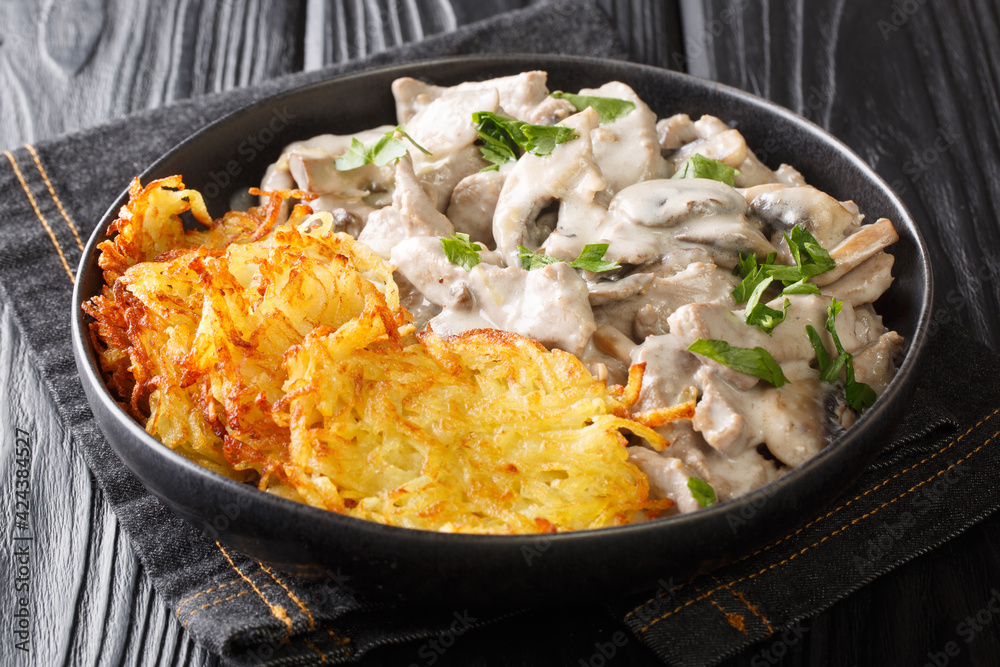 Zurcher Geschnetzeltes is a rich elegant dish of sliced veal, pan seared and drenched in a wine cream sauce in the plate on the table. Horizontal Zurcher Geschnetzeltes is a rich elegant dish of sliced veal, pan seared and drenched in a wine cream sauce in the plate on the table. Horizontal