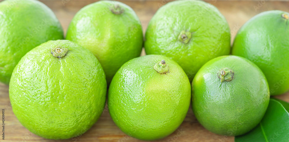 Green limes on wooden background Green limes on wooden background