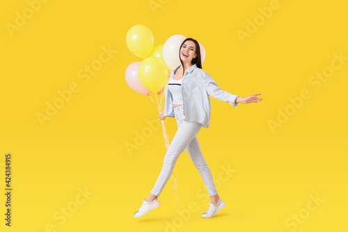 Beautiful young woman with balloons on color background © Pixel-Shot