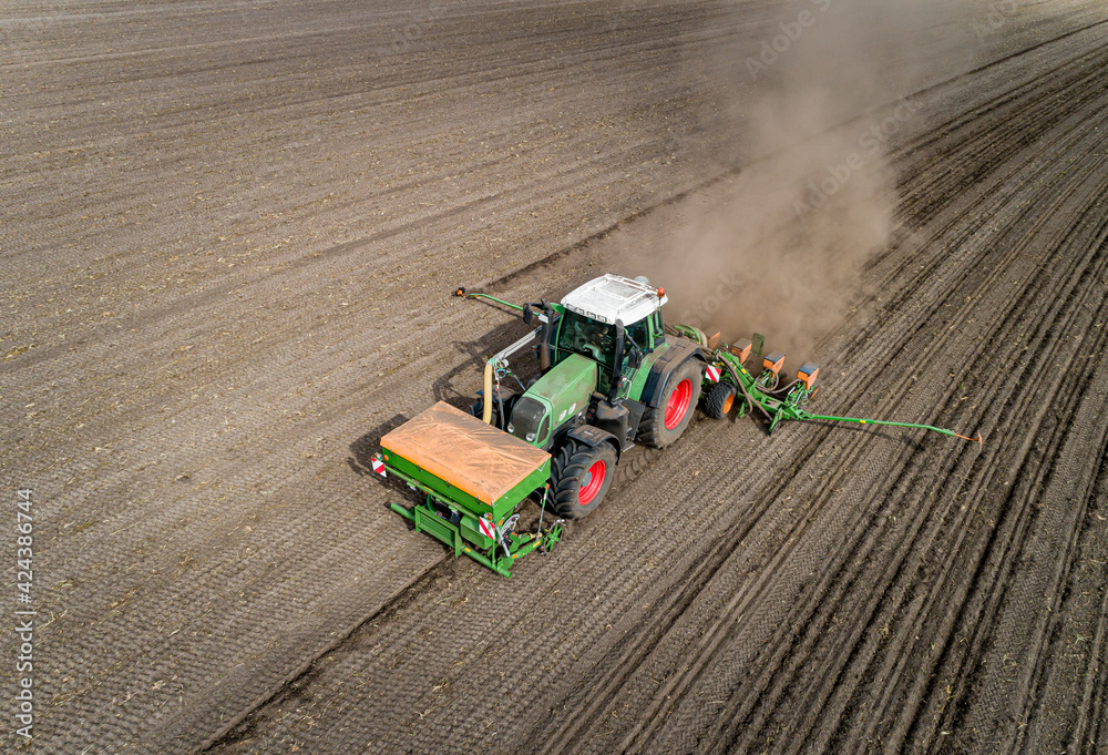 Landwirt mit moderner Landtechnik beim Maislegen, Luftbild - landwirtschaftliches Symbolfoto.