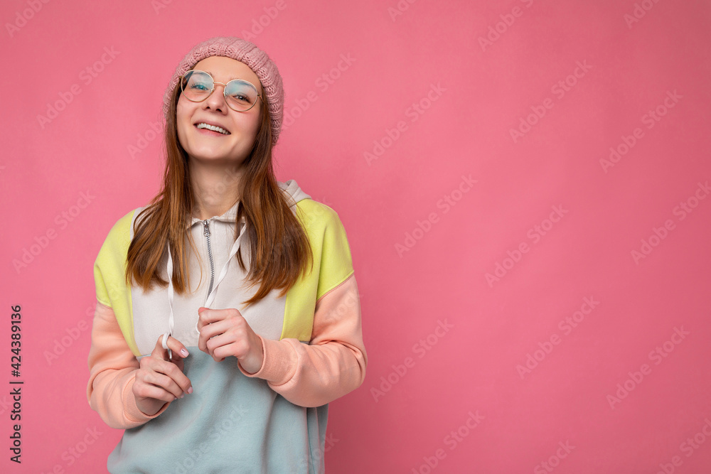 Photo shot of beautiful young blonde woman wearing casual clothes and stylish glasses isolated over colorful background looking at camera Photo shot of beautiful young blonde woman wearing casual clothes and stylish glasses isolated over colorful background looking at camera
