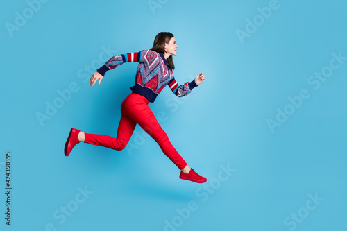 Full body profile side photo of young attractive girl happy smile jump up go walk run hurry sale isolated over blue color background