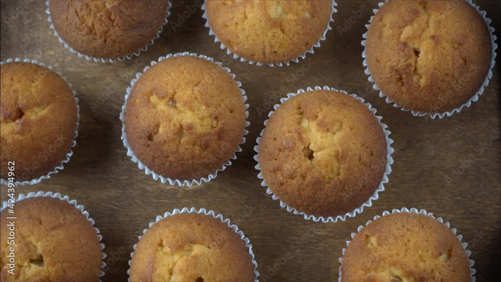 Muffins - delicious pastries. Baked dessert on the tabletop view. Homemade muffin. Portioned cupcakes. Simple food for party. Close-up muffins on a wooden tray. Muffins - delicious pastries. Baked dessert on the tabletop view. Homemade muffin. Portioned cupcakes. Simple food for party. Close-up muffins on a wooden tray.