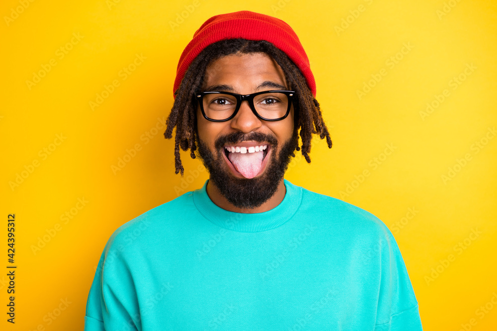 Photo of young african man happy positive fooling grimace tongue-out isolated over yellow color background