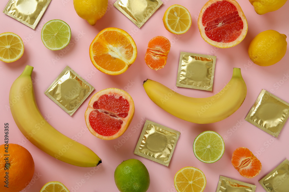 Sex concept with fruits and condoms on pink background - obrazy, fototapety, plakaty 
