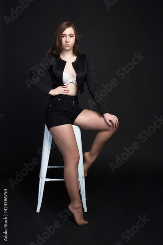 Young brown-haired woman, studio photo on a black background