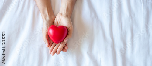Fototapeta Naklejka Na Ścianę i Meble -  Woman holding Red heart shape on white background. Healthcare, life Insurance, donation, health and World Heart Day concept