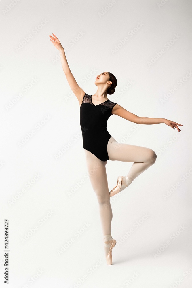 Ballerina posing in black body on grey background
