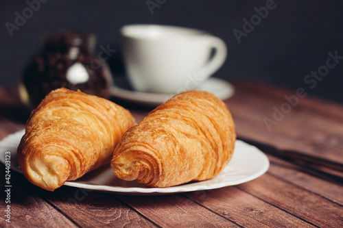 croissants in a plate a cup with a drink a meal dessert 