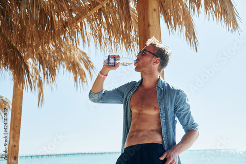 Posing for a camera. Young european man have vacation and enjoying free time on the beach of sea #424404942