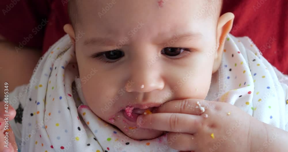 mother holds the baby in her arms and feeds her boy with a spoon. family, food, child, eating and parenthood concept mother holds the baby in her arms and feeds her boy with a spoon. family, food, child, eating and parenthood concept