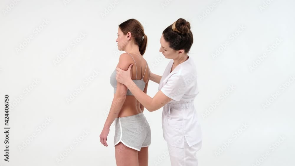 Physical Therapist Massaging Shoulder of a Female Patient. Over shoulder view of masseur performing deep tissue massage. 4k stock footage. close up video on white background Physical Therapist Massaging Shoulder of a Female Patient. Over shoulder view of masseur performing deep tissue massage. 4k stock footage. close up video on white background