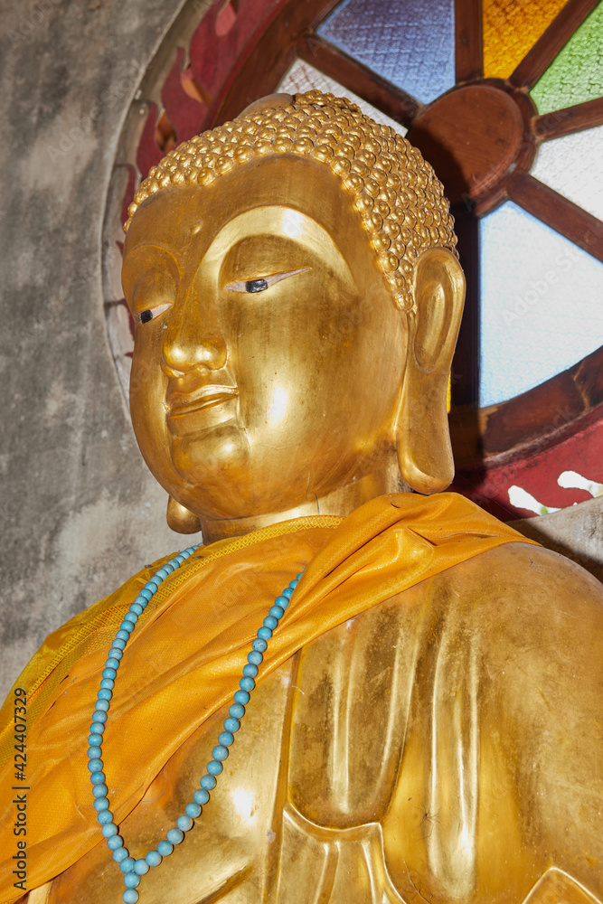 Phayao, Thailand - Dec 20, 2020: Portrait Zoom View Front Left Gold Buddha Statue in Chinese Temple at Wat Analayo Temple