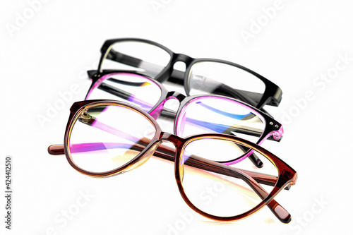 Glasses of different colors, in a plastic frame, with transparent optics, on a white background