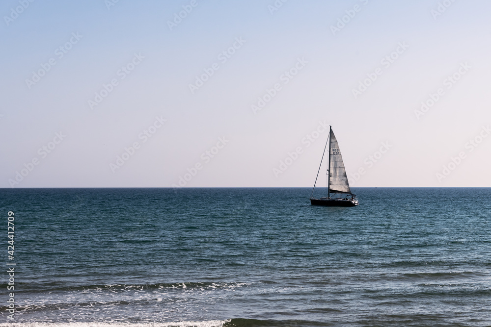 A sailboat sailing in the Mediterranean Sea on a sunny spring day