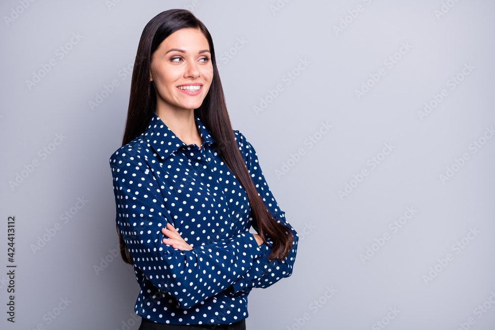 Photo of optimistic cute brunette girl crossed arms look empty space wear blue blouse isolated on grey color background
