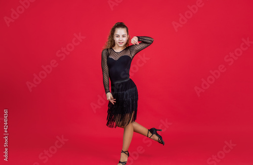 teen girl ballroom dancer. kid dancing in black dress. child in dance pose. professional slowfox and quickstep. waltz and tango. dancewear fashion clothes. dancing school