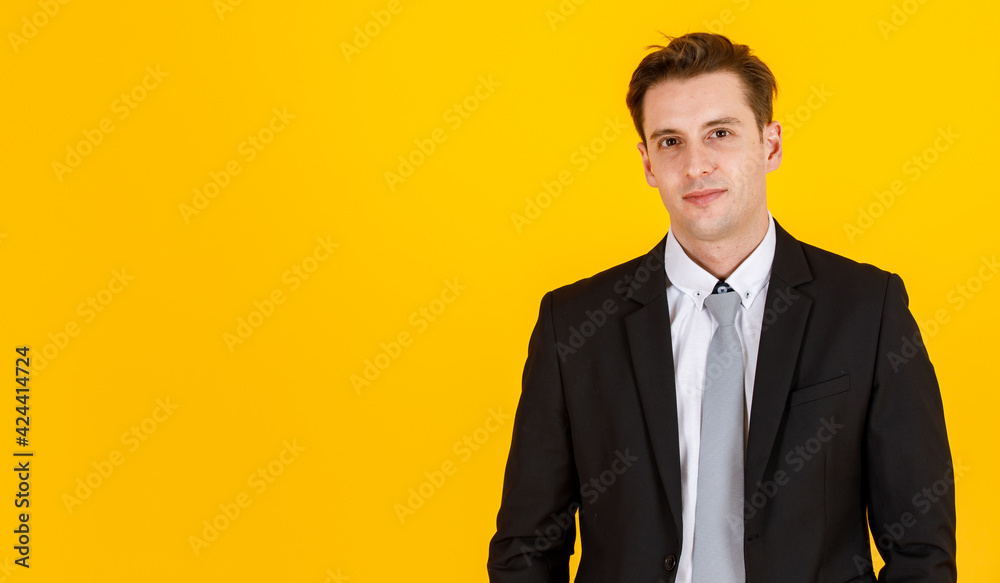 Studio shot isolated on yellow background of handsome and executive look caucasian businessman in black suit pose in boss action and positive smile face. Successful and happy business man concept Studio shot isolated on yellow background of handsome and executive look caucasian businessman in black suit pose in boss action and positive smile face. Successful and happy business man concept