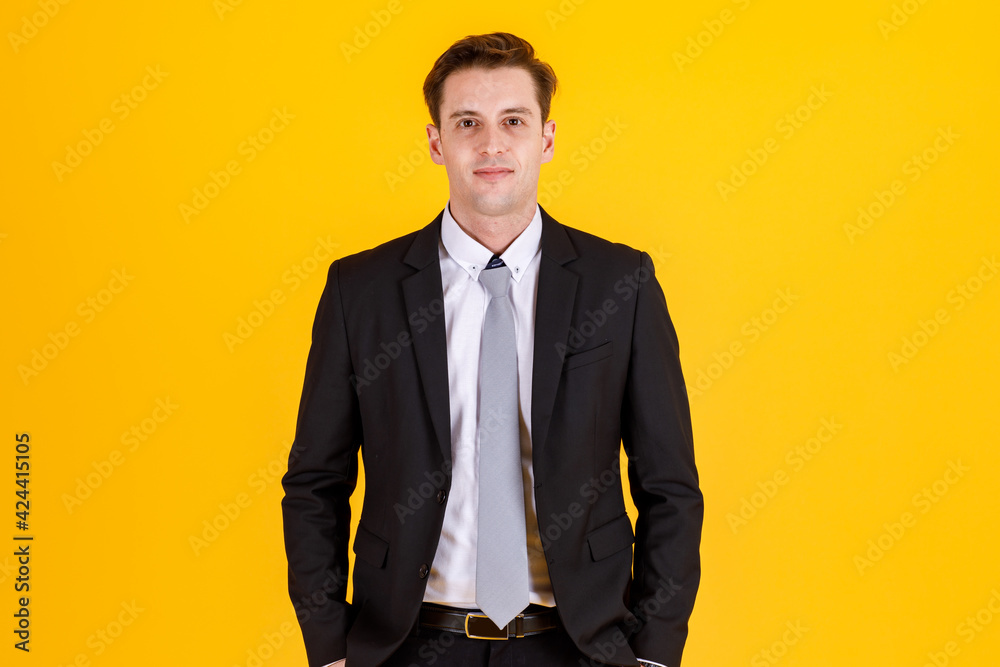 Portrait half body of handsome and executive look french businessman in black suit pose in boss action and positive smile face. Successful and happy business man concept on yellow background
