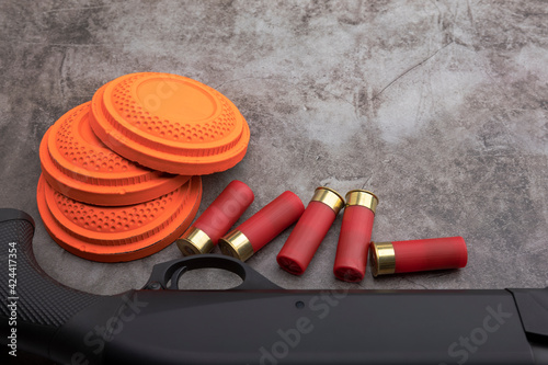 Clay disc flying targets and shotgun with bullet shells on texture background ,Clay Pigeon target game
