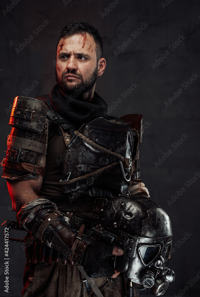 Bearded apocalyptic survivor with helmet in dark background