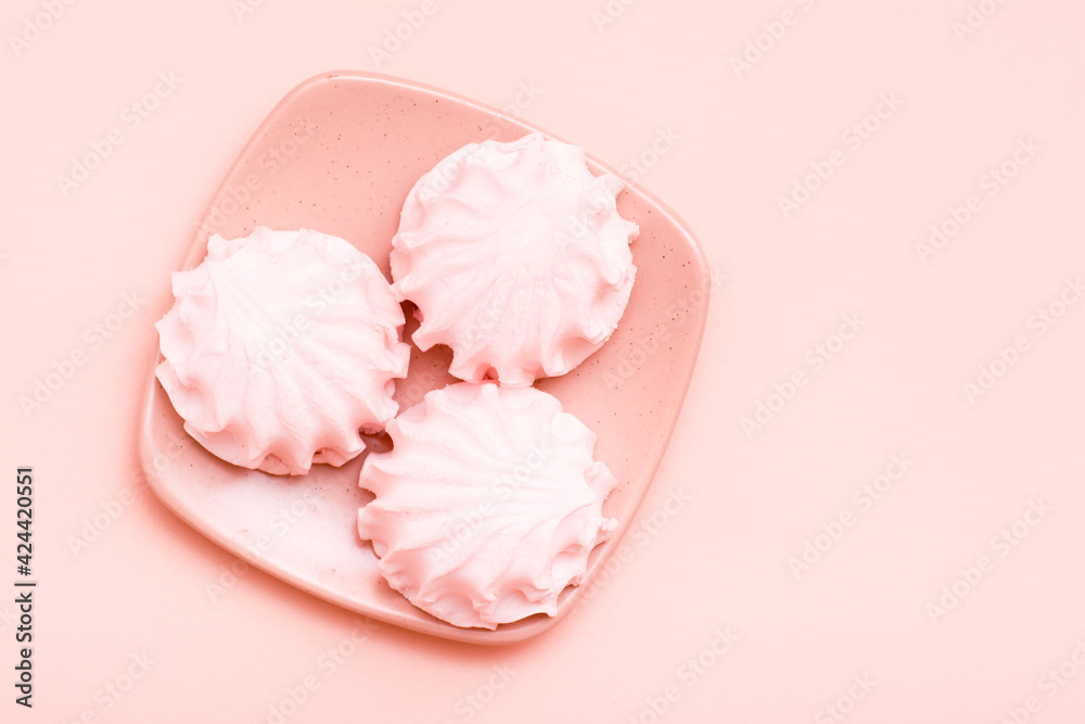 The concept is pink. Pink marshmallows on a saucer on a pink background. Top view