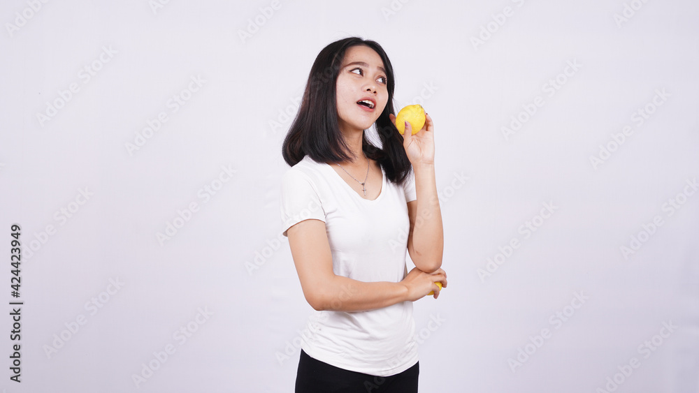 beautiful asian women thinking with a lemon isolated on white background beautiful asian women thinking with a lemon isolated on white background