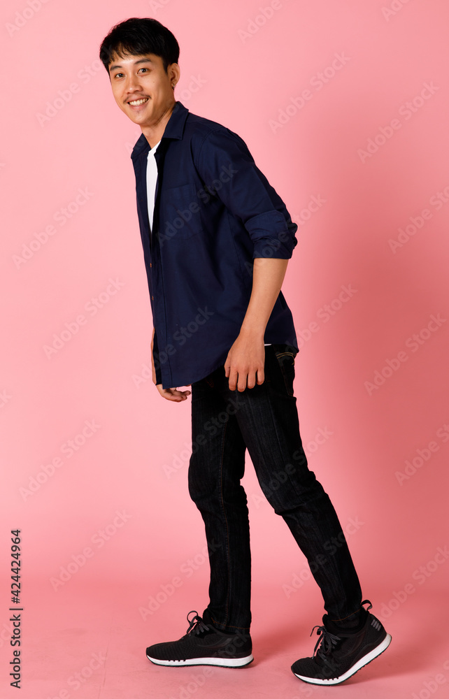 Portrait of young and cute Asian teen posing to camera with self-confidence and happy face. He looks like walking with a funny pose Portrait of young and cute Asian teen posing to camera with self-confidence and happy face. He looks like walking with a funny pose