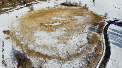 Lago riserva naturale coperto da vegetazione e neve fotografato dall'alto con un drone photo