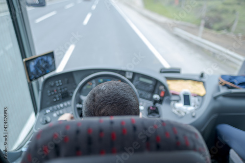 selective focus of a bus driver and his perspective in a bus traveling on highway