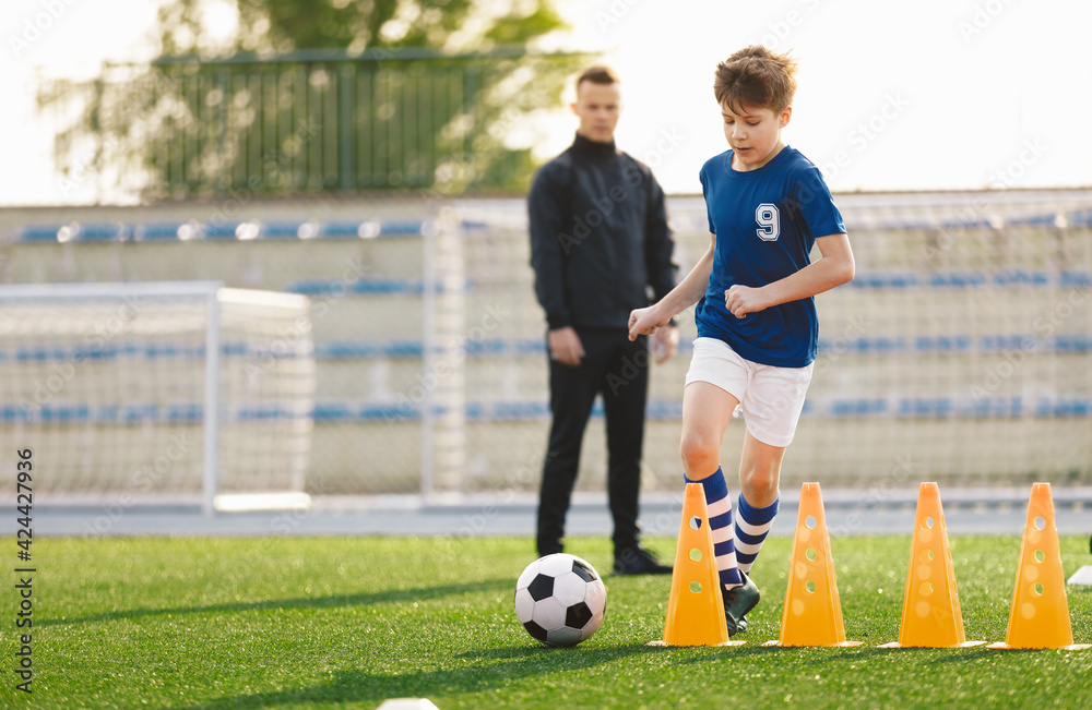 Sporty Soccer Boys Running Ball on Training Drill. Young Coach Watching Youth Football Team Practice Session. Kid Kicking Soccer Ball on Soccer Training Camp